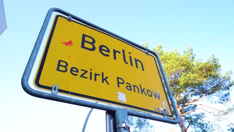 Close-Up-of-Yellow-Berlin-City-Sign-under-Blue-Sky-in-Pankow-District