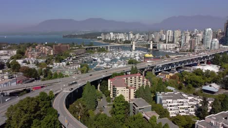 Luftpanorama-über-Die-Granville-Brücke,-Die-In-Die-Innenstadt-Von-Vancouver-Führt,-Der-Falsche-Bach,-Der-In-Die-Englische-Bucht-Von-Yaletown-Führt,-Der-Hauptstadtkern-Mit-Einem-Nebligen-Horizont-Der-Nordwest-Vancouver-Berge-1-2