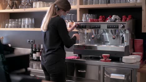 Barista-with-face-mask-is-working-on-the-coffee-machine-in-a-restaurant