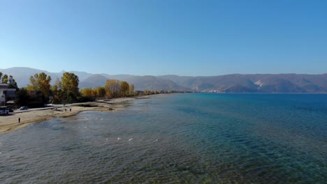 Fischerboote-Und-Menschen,-Die-Einen-Sonnigen-Herbstmorgen-Am-Ufer-Des-Ohridsees-Genießen
