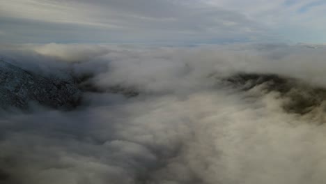 Flying-over-valley-covered-by-clouds