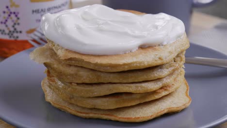 Topping-a-tall-stack-pf-pancakes-with-fresh-yogurt