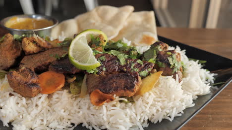 Tempting-plate-of-beef-kabob-with-veggies-and-naan,-slow-motion-close-up-slider-4K