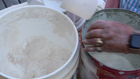 Newly-ground-whole-wheat-flour-scooped-and-moved-from-flour-mill-bin-to-baker's-container