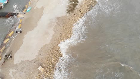 Luftaufnahme-Von-Oben-Nach-Unten-Von-Kleinen-Wellen,-Die-Den-Sand-In-Marsaxlokk-Malta-Treffen