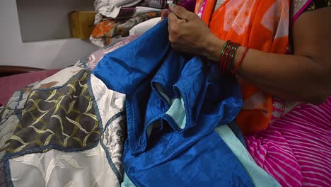 creating-woman-tearing-old-blue-bedsheet-for-making-curtains-for-her-home