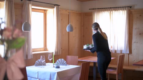 Waitress-with-face-mask-prepares-a-table-in-a-restaurant