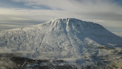 Zooming-out-drone-footage-of-Mount-Gaustatoppen-at-sunrise