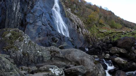 Felsiger-Kaskadierender-Wasserfall,-Der-In-Gezackte-Flussfelsen-Und-Felsbrocken-Im-Zeitraffer-Fließt