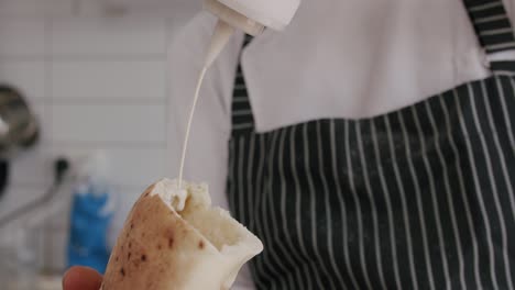 Chef-putting-tahini-inside-pita-bread
shot-at-100fps-2