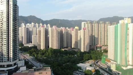Mega-Edificios-Residenciales-En-El-Centro-De-Hong-Kong-Y-Lion-Rock-Mountain-Ridge-En-El-Fondo,-Vista-Aérea