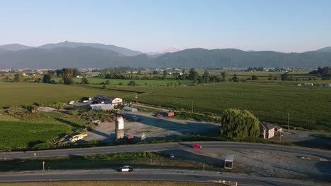 2-3-Mountain-Valley-farmland-Aerial-panout-over-winery-harvest-ready-crops-next-to-a-freeway-bypass-interstate-on-a-hot-sunny-day