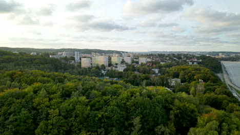The-Sky-View-Of-Lush-Green-Trees-Surrounding-Polanka-Redlowska-Trail-In-Gdynia-Poland-Under-The-Cloudy-Sky---Aerial-Shot
