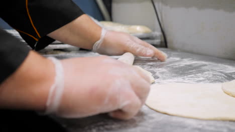 Slow-motion-slide-closeup-chef-rolling-out-naan-dough-Indian-flat-bread----4K