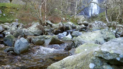 Idyllischer-Bergwald-Wasserfall,-Der-Rechts-In-Zerklüftete-Flussbrocken-Fließt