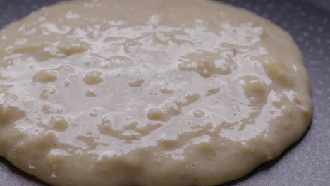 Extreme-close-up-of-pouring-pancake-batter-on-a-hot-pan