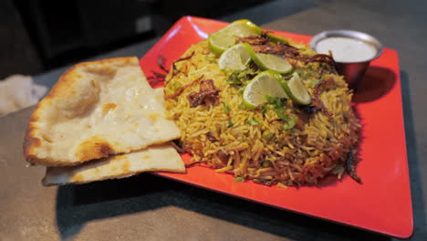 Authentic-Indian-rice-dish-Biryani-naan-raita-sauce,-orbit-HD