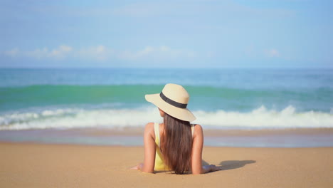 Woman-Lying-On-Sandy-Beach,-Looking-Over-Waves-In-Slow-Motion