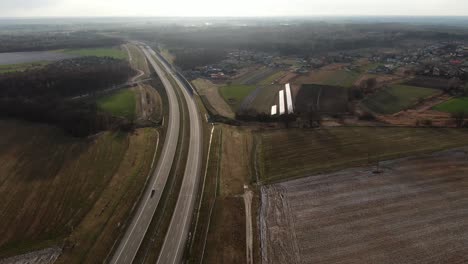 Aerial-Calm-Curved-Highway-in-Winter-Between-The-Fields