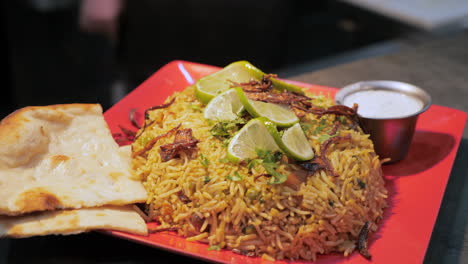 Biryani-with-naan-and-raita-plated-for-serving-in-restaurant,-slider-pull-slow-motion-HD