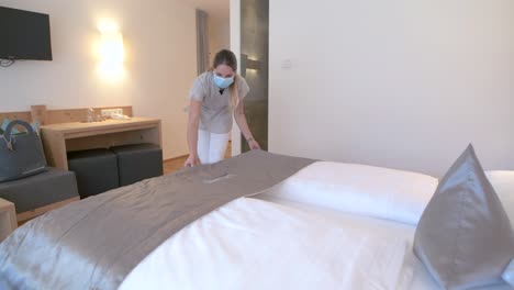 Hauswirtschaft-Mit-Gesichtsmaske-Bereitet-Das-Bett-In-Einem-Hotelzimmer-Vor