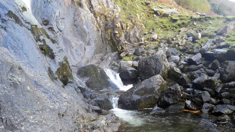 Felsiger-Gebirgswasserfall,-Der-über-Zerklüftete-Flussbrocken-In-Einem-Schroffen-Ländlichen-Tal-Fließt