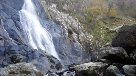Felsiger-Wasserfall,-Der-In-Zerklüftete-Flussfelsen-Und-Felsbrocken-Fließt,-Langsam-Nach-Rechts