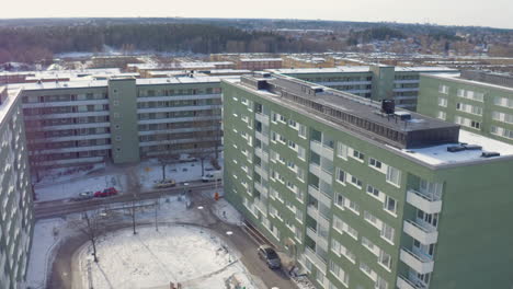 Aerial-view-of-Stockholm-suburb-Husby,-green-houses,-drone-in-winter