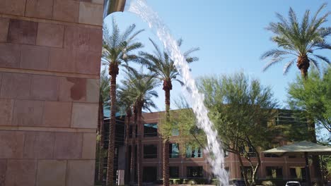 Tilt-up-from-the-retention-pond-to-the-top-of-a-30-foot-tall-brick-fountain,-Scottsdale,-Arizona