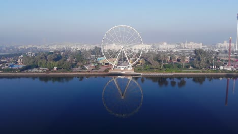 Drone-Camera-view-of-the-iconic-Eye-of-the-Emirates-wheel-the-most-visible-landmark-at-Al-Montazah-Park-in-Sharjah-at-Al-Montazah-Park,-United-Arab-Emirates,-4K-video