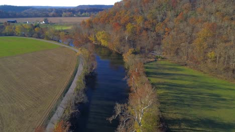 Aerial-shot-flying-over-Elkhorn-Creek-farmhouse-in-the-distance-truck-traveling-on-a-country-road