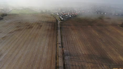 Car-Overtaking-On-an-Empty-Road-Between-Fields-Blizzard-Starting-Aerial