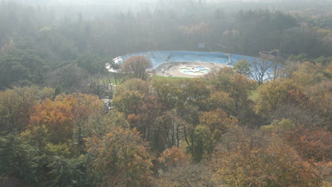 Aerial-reveal-of-deserted-swimming-pool-in-the-middle-of-forest