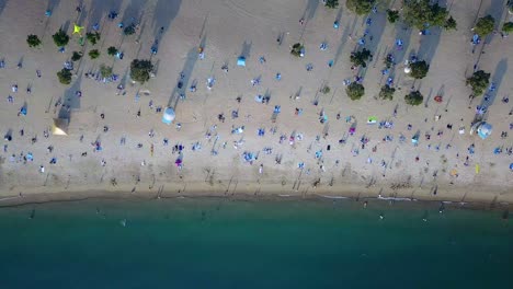 A-static-aerial-view-of-visitors-at-Repulse-Bay-beach-in-Hong-Kong-as-public-beaches-reopening,-after-months-of-closure-amid-coronavirus-outbreak,-to-the-public