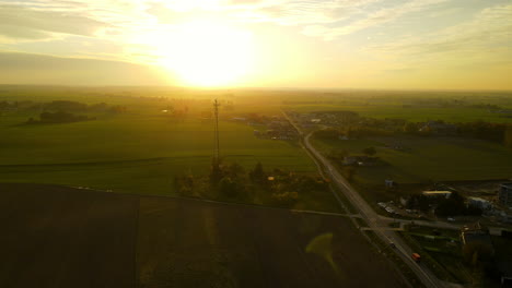 Ein-Gelber-Sonnenuntergang-über-üppigen-Grünen-Feldern-In-Lubawa,-Portugal---Luftdrohnenaufnahme