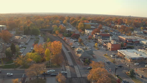 Aerial-view-of-downtown-Kirkwood-at-train-station-with-cars-crossing-the-tracks-in-the-Fall-at-golden-hour-in-November-with-a-rise