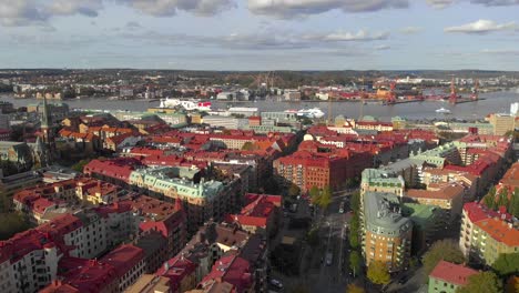 Aerial-of-Gothenburg-city-with-many-buildings,-river-and-port,-arc-shot