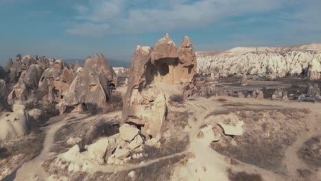 Pull-back,-4k-aerial-drone-footage-of-the-remains-of-a-carved-home-in-Cappadocia-of-central-Turkey