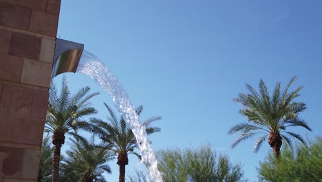 Slight-pan-from-the-open-sky-to-the-spout-of-a-30-foot-fountain,-Scottsdale,-Arizona