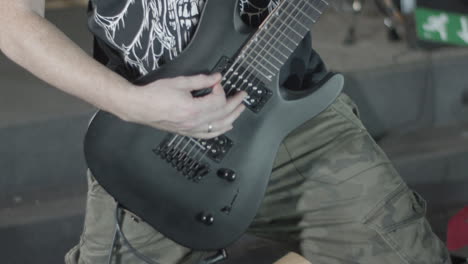Guitarist-playing-on-a-black-seven-string-guitar