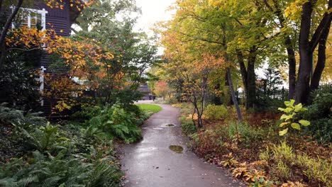 Empty-path-next-to-residential-building-surrounded-by-trees-in-fall-colors