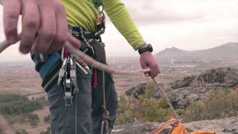 Rock-climber-with-a-climbing-equipment-taking-out-a-rope-from-a-bag