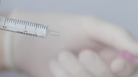 Hand-Removes-Hypodermic-Needle-From-A-Syringe---Medical-Concept---close-up