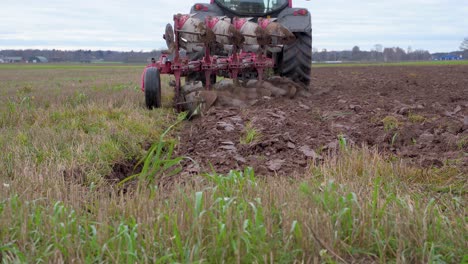 Back-view-of-farm-tractor-plowing-land