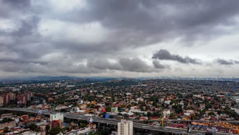 Lapso-De-Tiempo,-Nubes-De-Tormenta-En-El-Paisaje-De-La-Ciudad-De-México-Con-Tráfico,-Hiperlapso-Aéreo