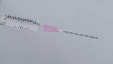 Attaching-Needle-To-Syringe-With-Fluid---Coronavirus-Vaccine-Concept---close-up