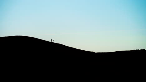 wide-shot-of-Silhouette-Of-men-doing-topographic-surveys-on-hill-top