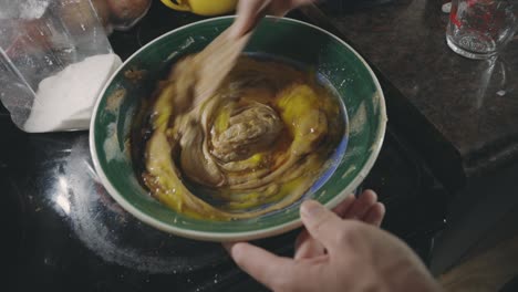Mixing-Cookie-Batter-And-Fresh-Eggs-In-A-Bowl-With-A-Wooden-Spoon---close-up
