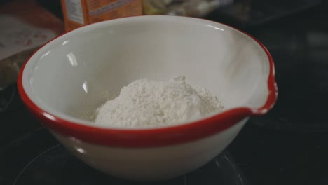 Pouring-A-Cup-Of-White-Flour-Into-A-Bowl---close-up