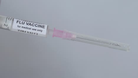 Hand-Removes-Cap-Of-Flu-Vaccine-Syringe---Medical-Concept---close-up